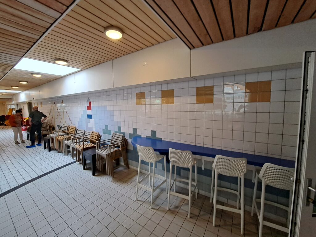 Fotowanden over tegelmuur bij renovatie openbaar zwembad